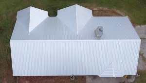 Aerial view of modern white metal roof on residential building with geometric design