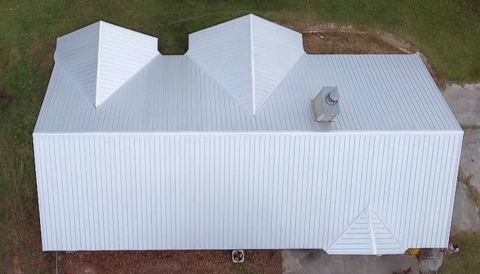 Aerial view of modern white metal roof on residential building with geometric design