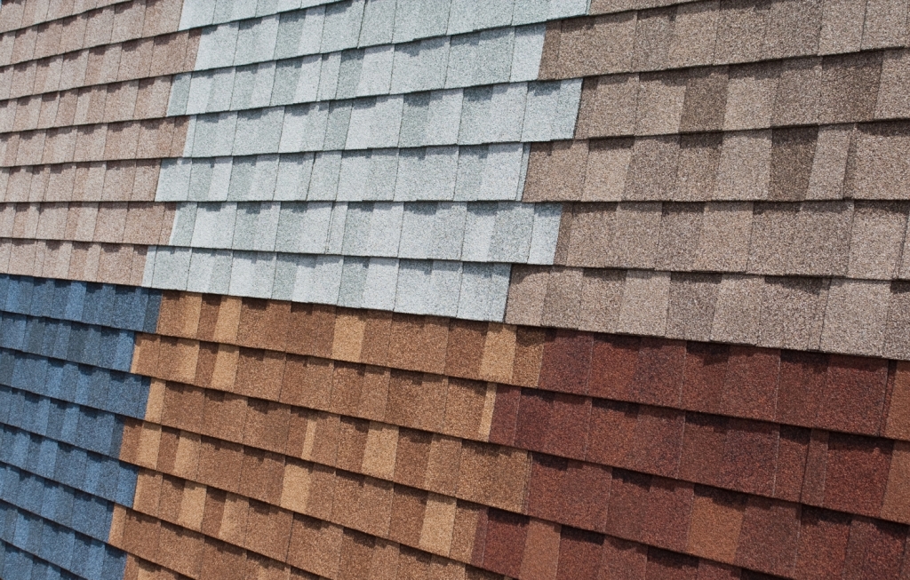 Colorful asphalt roofing shingles display in various shades including blue, brown, gray and red