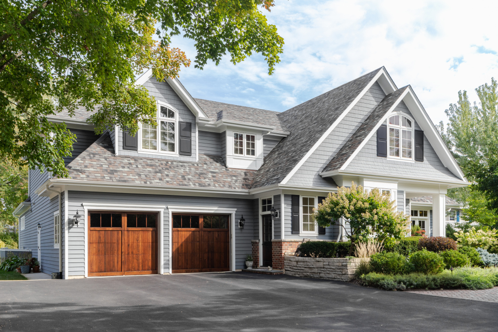 Gray two-story house with wooden garage doors and landscaped front yard