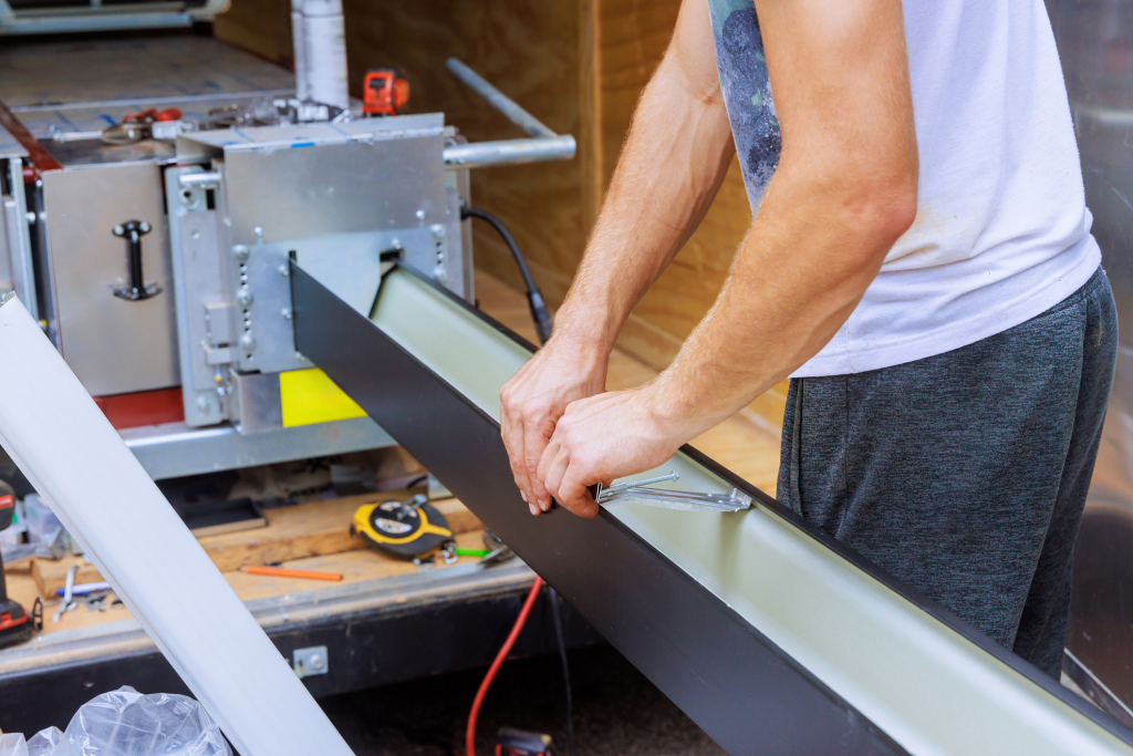 Person operating woodworking machinery in workshop with hands positioned on equipment