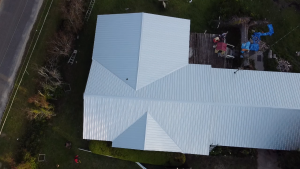 Aerial view of large industrial building with white corrugated metal roof