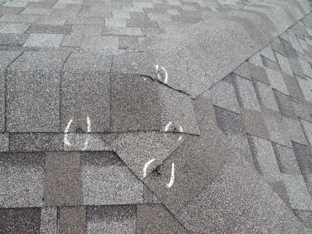 White chalk graffiti markings and symbols drawn on gray asphalt road surface