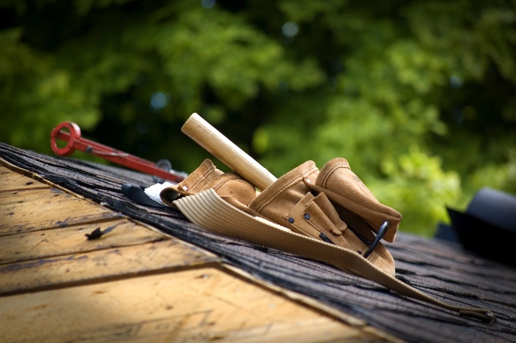 Leather tool belt with hammer and construction tools on wooden surface outdoors